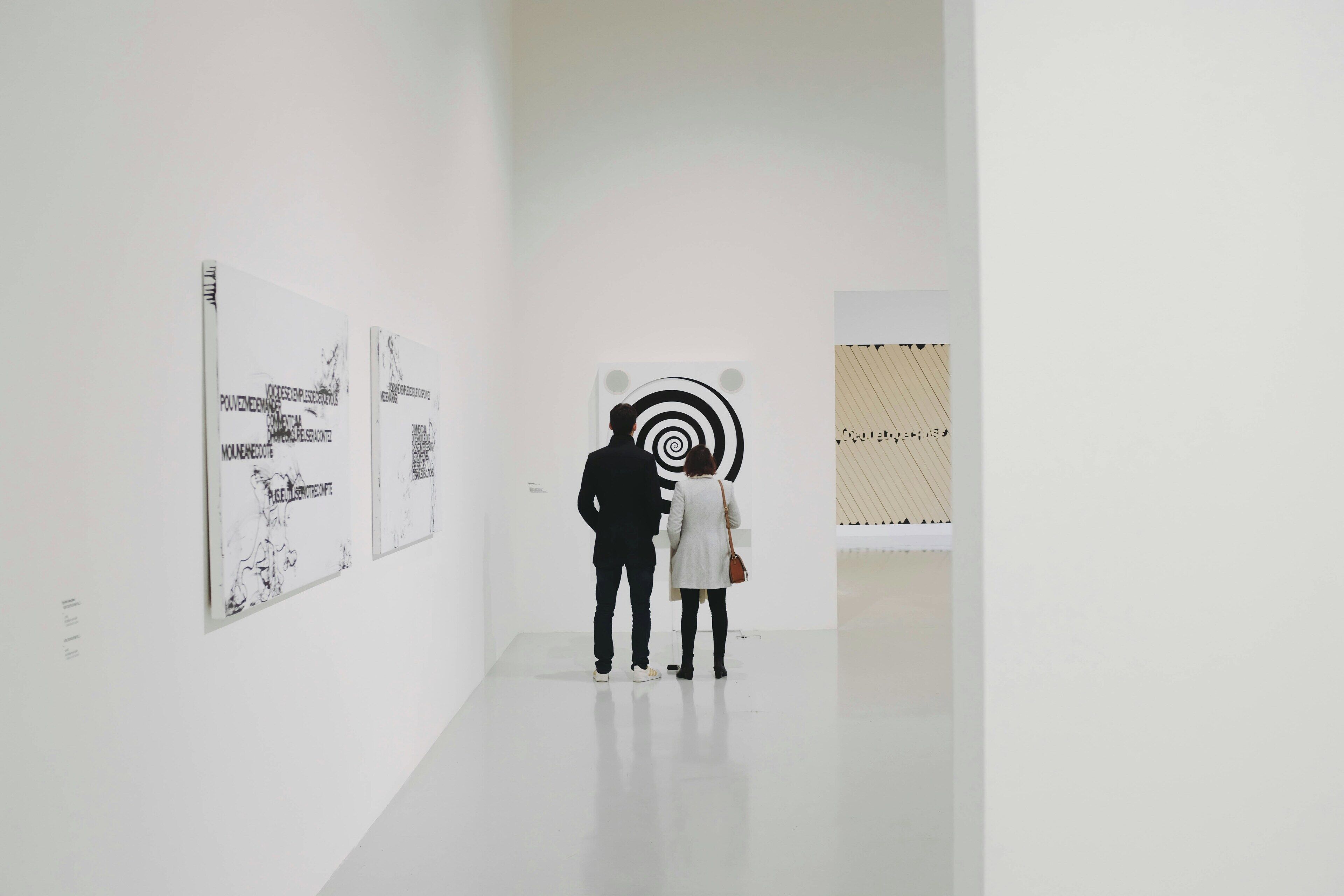 A modern art gallery with white walls and minimalist decor.