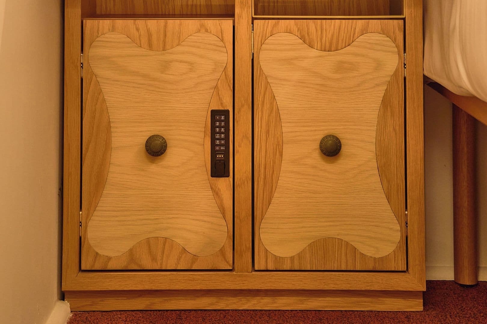 Una puerta doble de madera con un panel de control y dos pomos redondos.