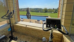 Una habitación con ventana que da a una piscina y un paisaje con césped.