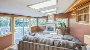 Ein Schlafzimmer mit einem großen Bett, einem Kamin und Blick ins Freie.