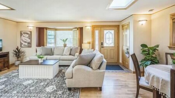 Ein geräumiges Wohnzimmer mit einer großen Couch, einem Couchtisch und einem Essbereich mit Tisch und Stühlen.