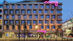 A multi-story hotel with a prominent neon sign reading "mozy" on the facade. - Moxy Antwerp (Antwerp)