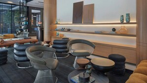 A modern lounge area with contemporary furniture, a fireplace, and a bookshelf. - Gymnasia Isrotel, A Tribute Portfolio Hotel (Tel Aviv)