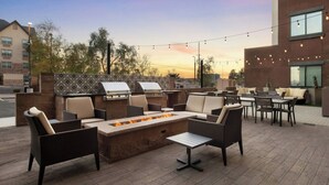 An outdoor patio with a fire pit, seating, and a grill area. - Residence Inn By Marriott Yuma (Yuma)