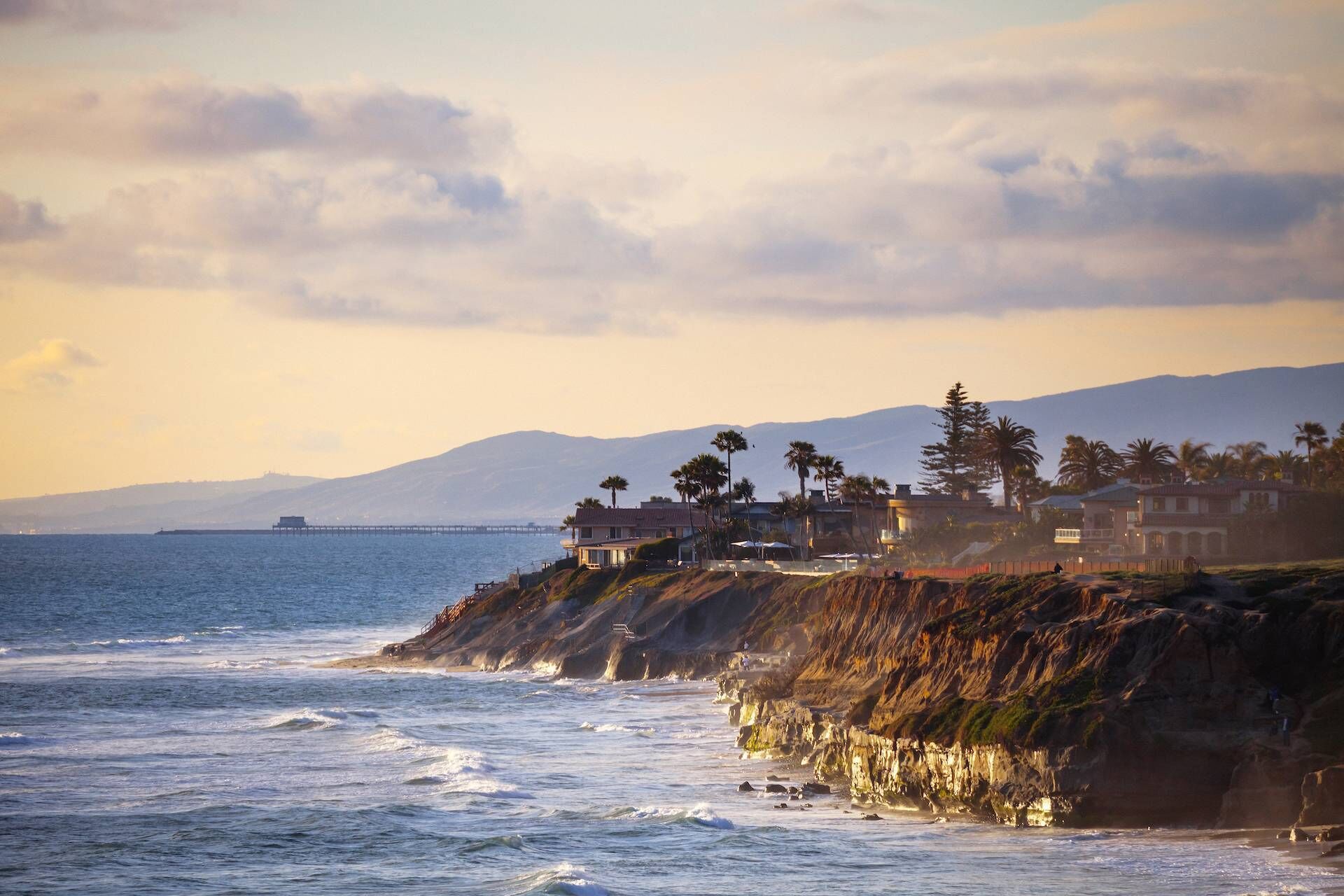 A coastal property with a view of the ocean and mountains in the background.