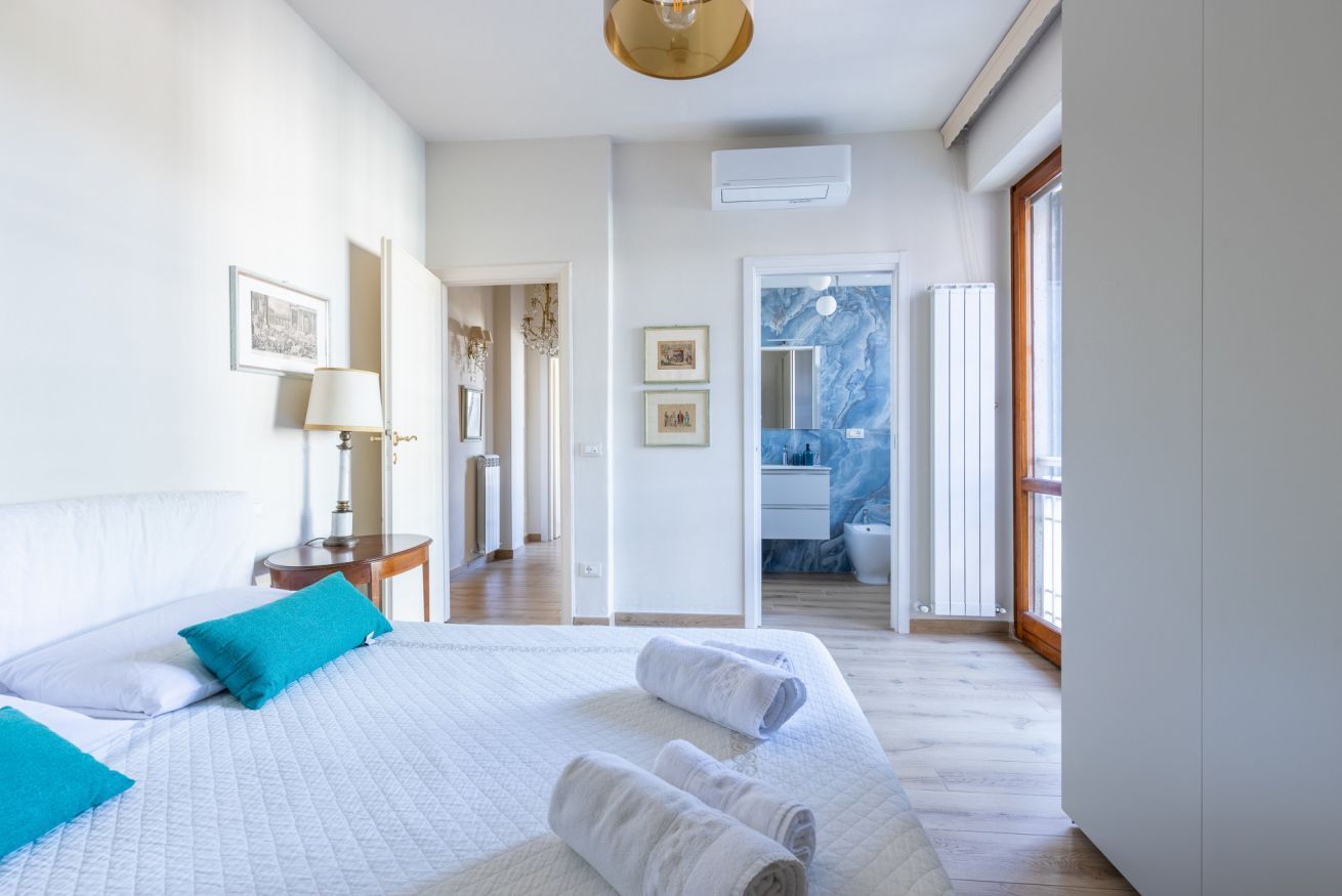 Une chambre d’hôtel avec un grand lit, une table de chevet, une lampe et une vue sur la salle de bain.