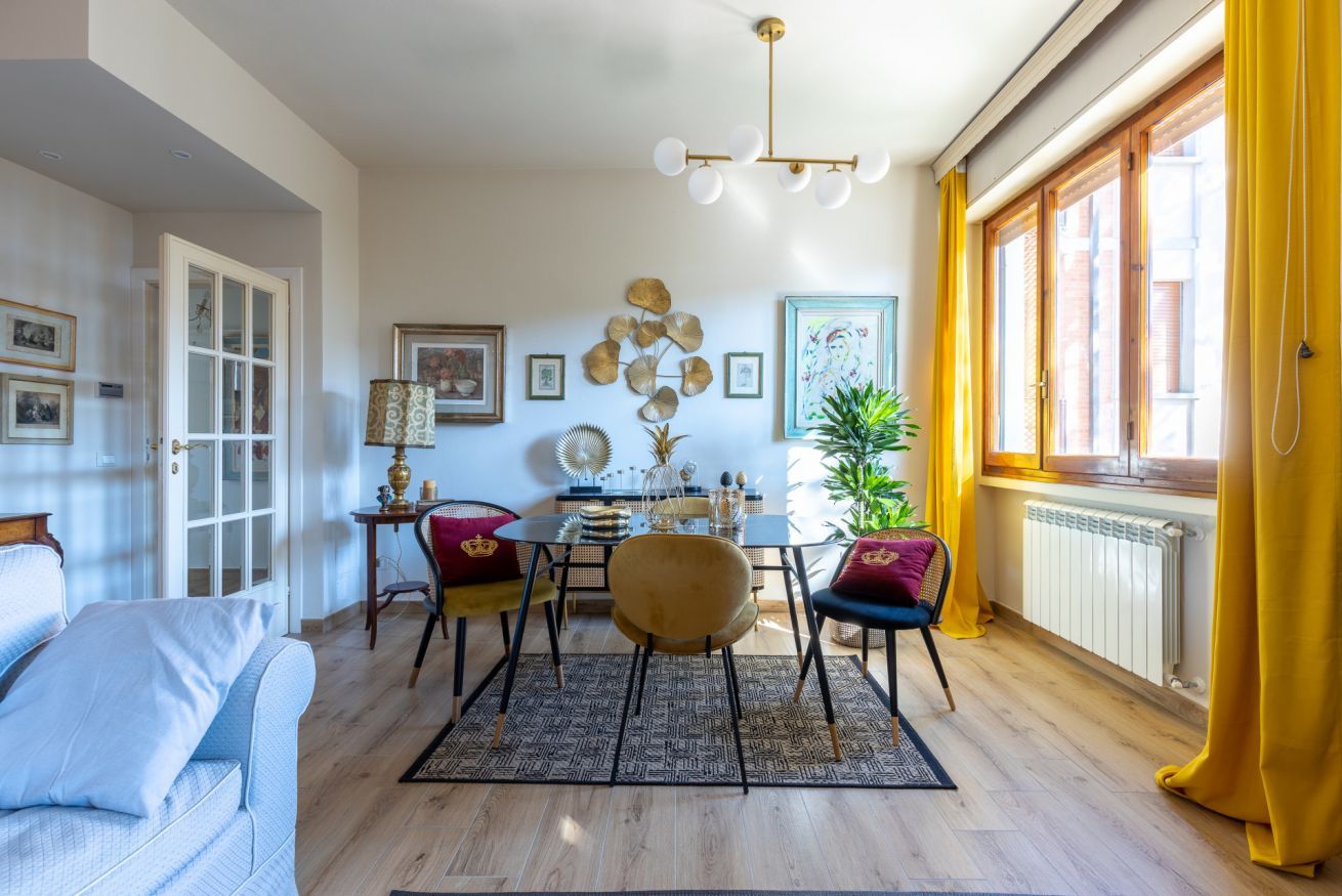 A dining area with a table, chairs, and a chandelier.
