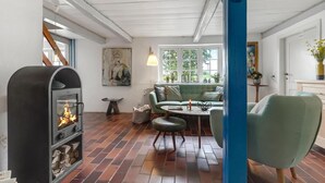 Uma sala de estar acolhedora com lareira, sofá, mesa de centro e uma parede azul.
