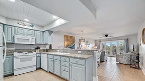 Eine moderne Küche mit hellblauen Schränken, einer Granit-Arbeitsplatte und einem eingebauten Backofen.