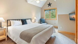 Ein Schlafzimmer mit einem großen Bett, einem Deckenventilator, einer Sternen-Dekoration, einem Fenster und einem Fernseher an der Wand.