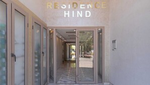 A modern entrance with a glass door and a sign reading "RESIDENCE HIND". - Cosy new apartment Gueliz (Marrakech)
