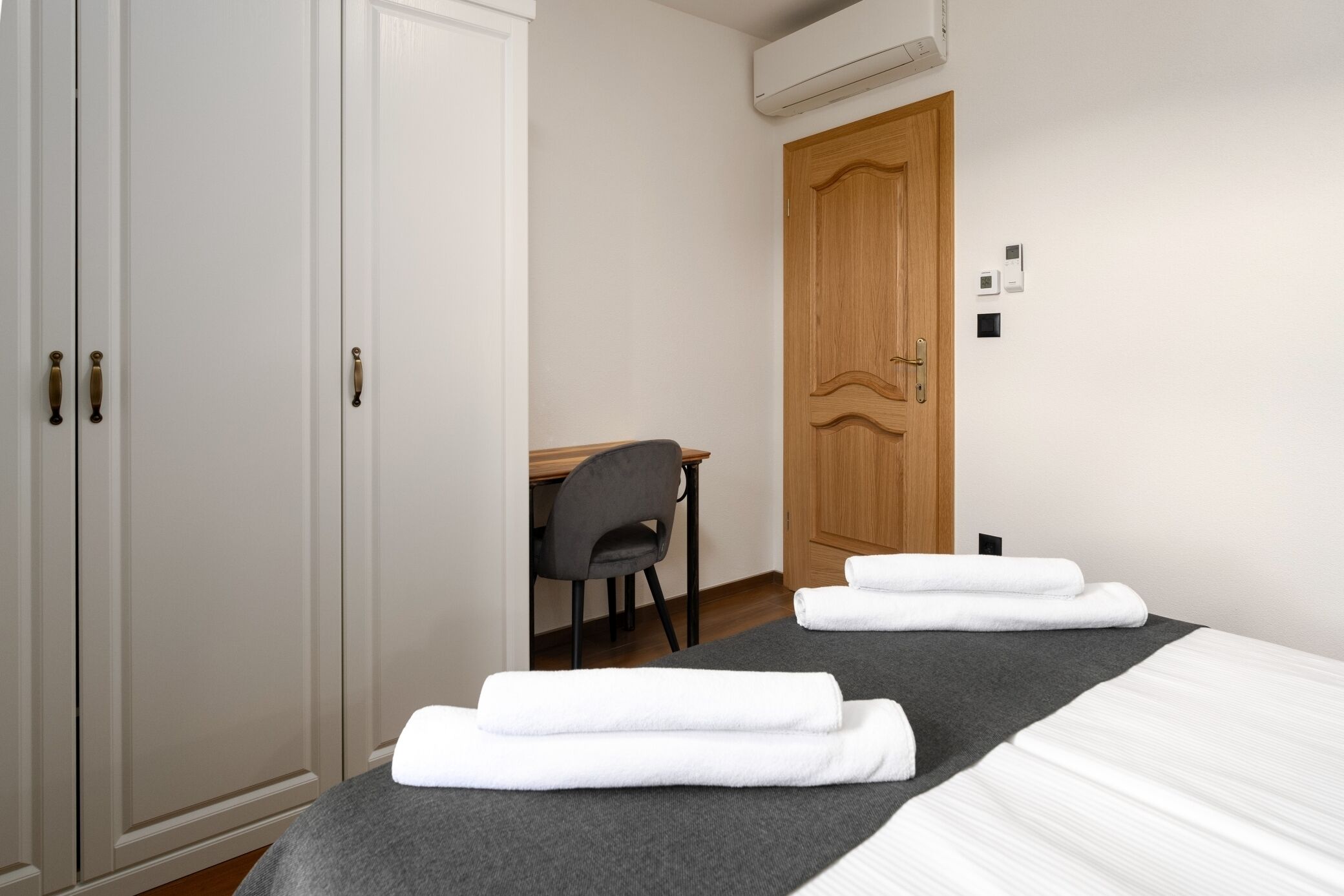 Une chambre d’hôtel avec un lit, un bureau et une armoire.