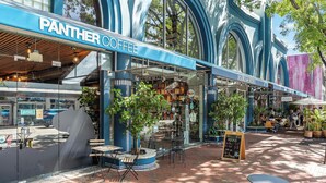 A coffee shop with a blue exterior and a bookstore named 'Books & Books' adjacent to it.