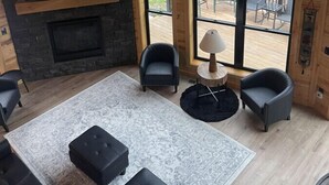 A spacious living room with a large TV, fireplace, and multiple seating areas.