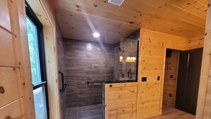 A wooden interior with a kitchen area, a window, and a door.