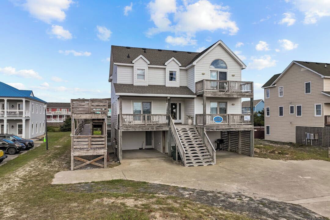 A two-story house with a balcony, a front porch, and a driveway.