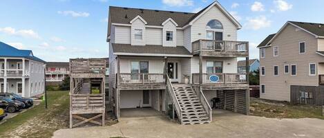 A two-story house with a balcony, a front porch, and a driveway.
