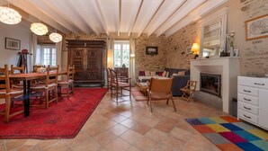 Amplia sala de estar con chimenea, muebles de madera y alfombra roja.
