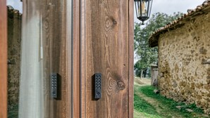 Eine Holztür mit Zahlenschloss und einer Laterne.