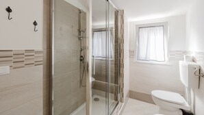 A modern bathroom with a glass shower enclosure, a toilet, and a window with curtains. - Room 'Camera 1' with Balcony, Wi-Fi and Air Conditioning (San Giuseppe Jato)