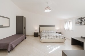 Una camera da letto moderna con un letto, comodini, un armadio e una scrivania.