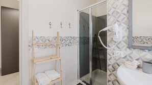 A bathroom with a glass shower enclosure, a wooden towel rack, and a sink with a mirror. - Room "Camera 2" with Balcony, Wi-Fi, and Air Conditioning (San Giuseppe Jato)