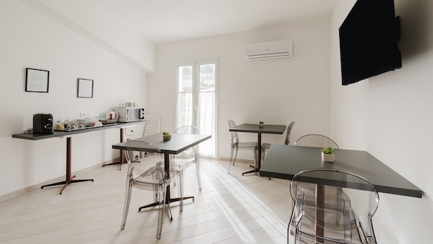 A modern kitchen with a countertop, a dining area with a table and chairs, and a large window. - Room 'Camera 3' with Balcony, Wi-Fi and Air Conditioning (San Giuseppe Jato)
