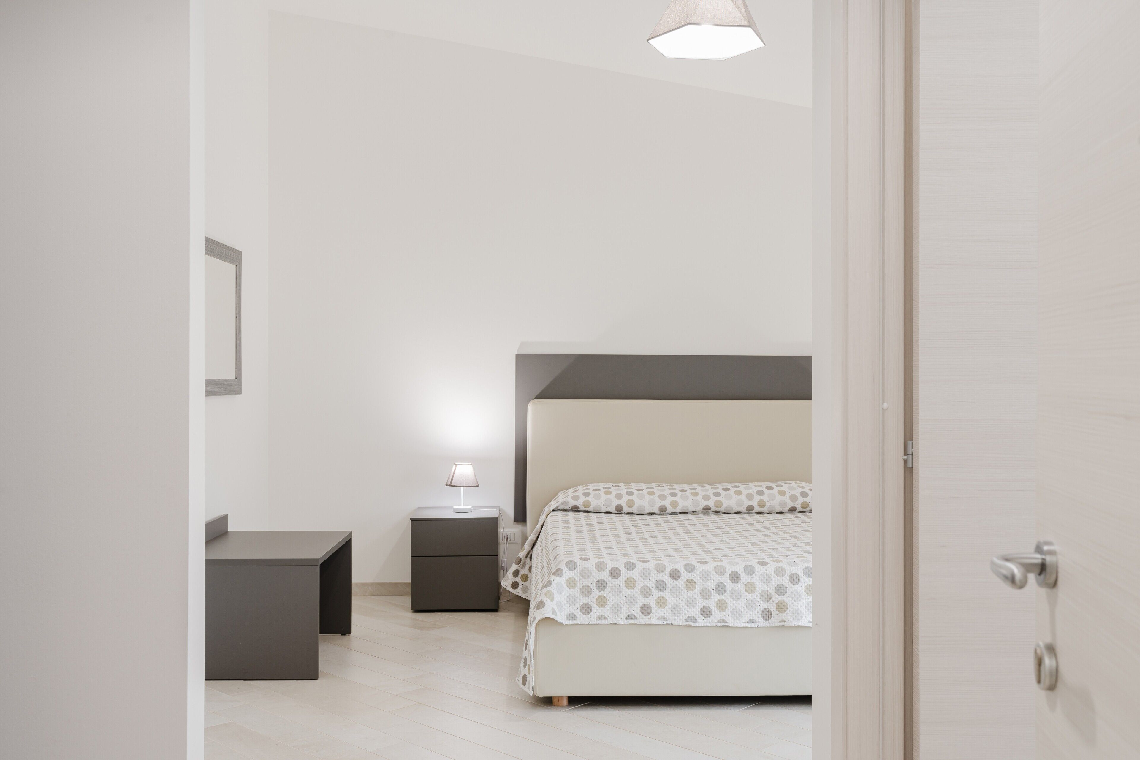 A bedroom with a bed, bedside table, and a nightstand.