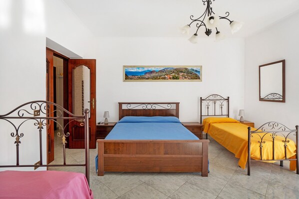Une chambre à coucher avec un lit en bois, une table de chevet, une commode, un miroir et un tableau accroché au mur.