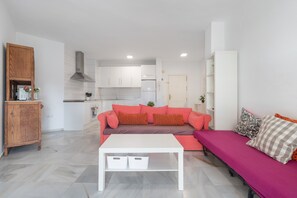 Un salon moderne avec un canapé, une table basse et une cuisine en arrière-plan.