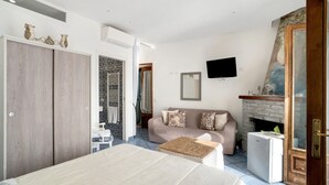 Une chambre à coucher comprenant un lit, un canapé, une télévision, une cheminée et une armoire.