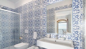 Une salle de bain avec un lavabo blanc, des toilettes, un bidet et une douche.