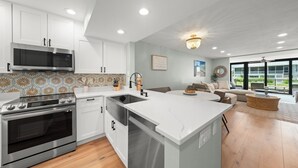 Una cocina moderna con armarios blancos, electrodomésticos de acero inoxidable y una isla grande.