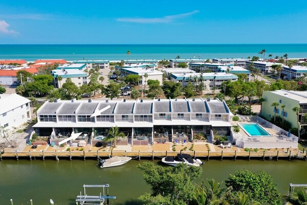 A coastal hotel with a pool, multiple buildings, and a marina.