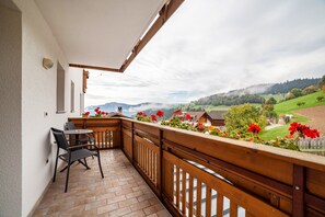A balcony with a wooden railing, a table, and chairs. - Room 'Klausthaler Zimmer 14' with Mountain View, Shared Terrace and Wi-Fi (Meltina)