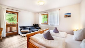 Une chambre avec un lit en bois, un canapé et une vue sur un jardin.