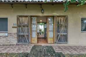 A building entrance with wooden doors, a tiled patio, and a hanging lantern.
