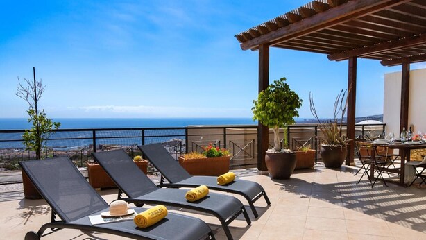 A terrace with sun loungers, a table, and potted plants. - Holiday Apartment 'Obsidian Villa Bentayga' with Sea View and Wi-Fi (Adeje)