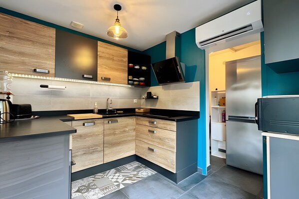 A modern kitchen with a built-in stove, a sink, and a refrigerator.