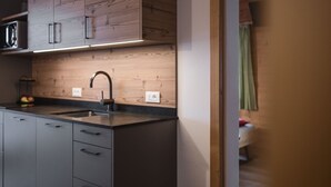 A modern kitchen with wooden cabinets, a black countertop, and a sink.