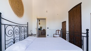 Un dormitorio con cama, un armario de madera, una puerta y un tapiz tejido en la pared.