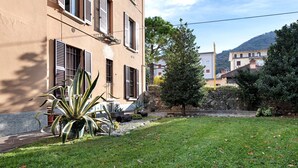 A building with a garden, a tree, and a mountain in the background. - Casa Vacanze Da Rosa Apartment – Step-Free Access, Family-Friendly, Central Iseo (Iseo)