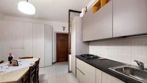 A kitchen with a black countertop, stainless steel sink, and wooden cabinets. - Casa Vacanze Da Rosa Apartment – Step-Free Access, Family-Friendly, Central Iseo (Iseo)
