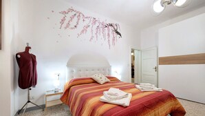 A bedroom with a bed, a mannequin, a wall-mounted light, and a door. - Casa Vacanze Da Rosa Apartment – Step-Free Access, Family-Friendly, Central Iseo (Iseo)