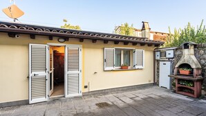 A building with a tiled roof, a stone oven, and a door leading to an interior space. - Dependance 'Residence Al Pozzo' with Wi-Fi and Air Conditioning (Capannori)