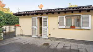A residential building with a tiled roof, a gated entrance, and a small window with shutters. - Dependance 'Residence Al Pozzo' with Wi-Fi and Air Conditioning (Capannori)