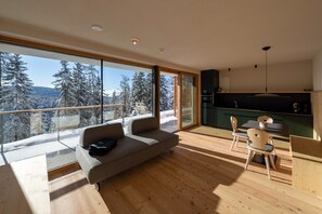 En modern inredning med en soffa, ett matbord, stolar och ett köksområde.