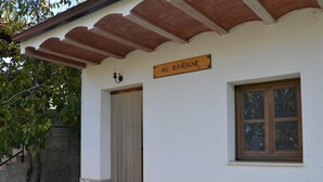 Un edificio con base in pietra, una porta in legno, una finestra e un cartello sopra la porta.