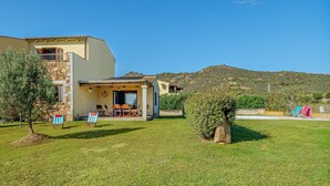 Una casa con un patio, mobiliario exterior y vistas a las colinas.