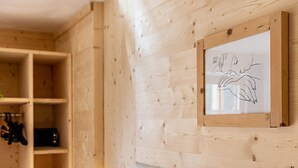 Een houten wand met een ingelijst tekening en een wandplank.